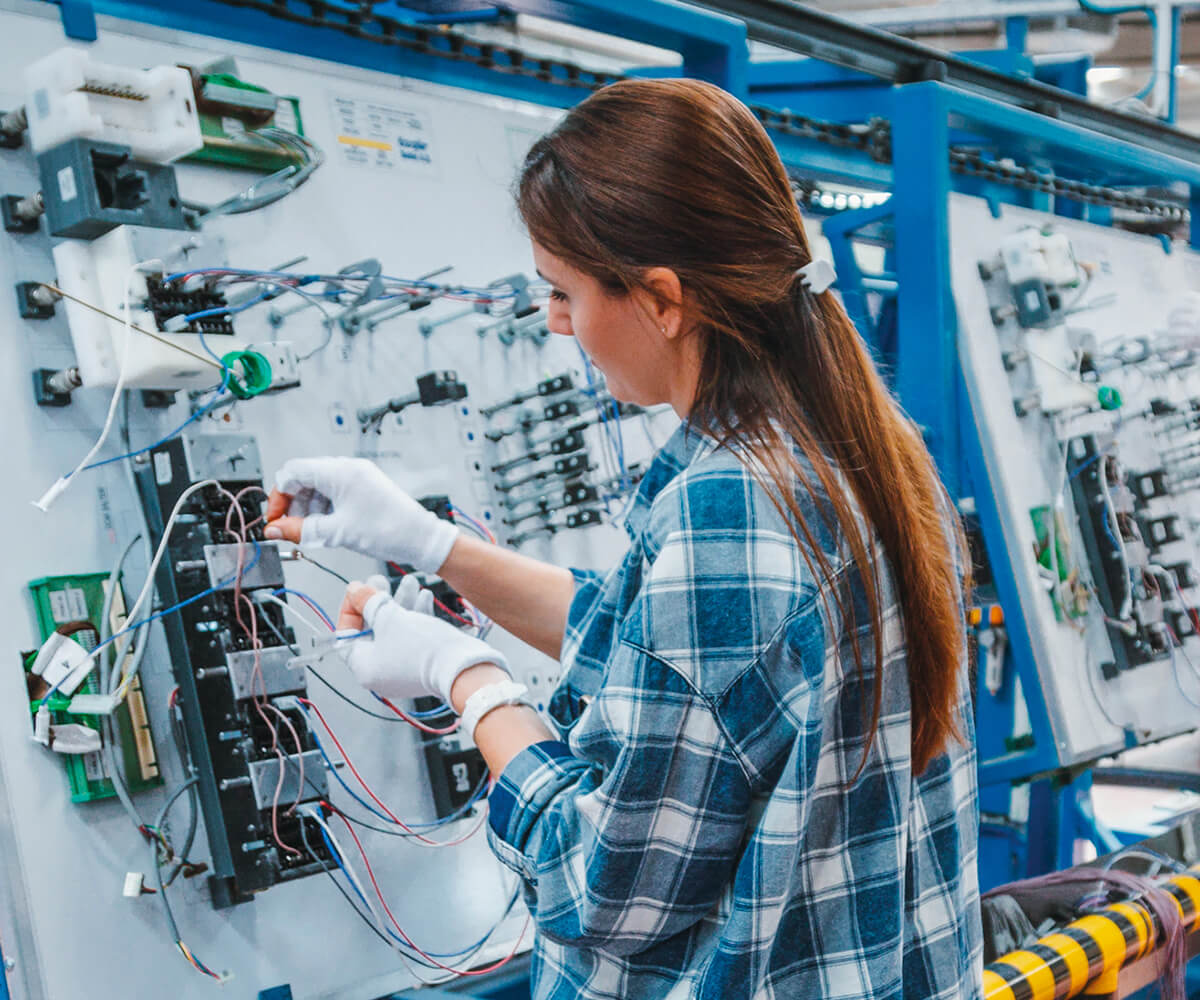 A female engineer working on a machine in a factory